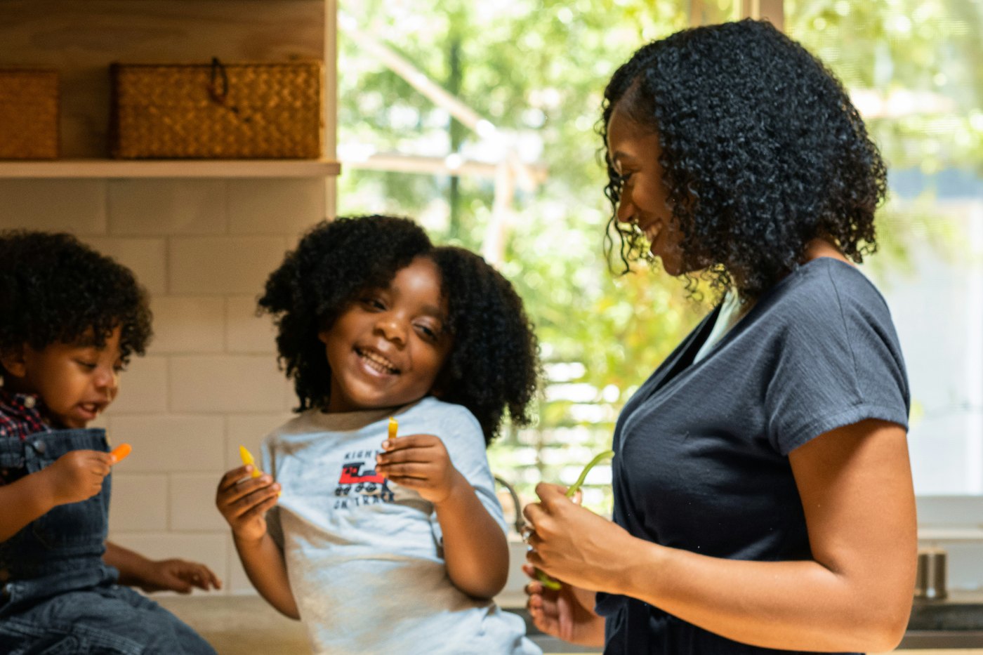 A mother and her two children in the kitchen, mid-morning