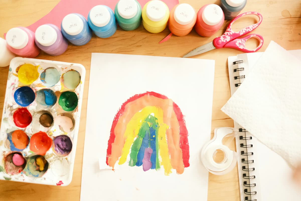 A watercolor rainbow drying beside the paint tray