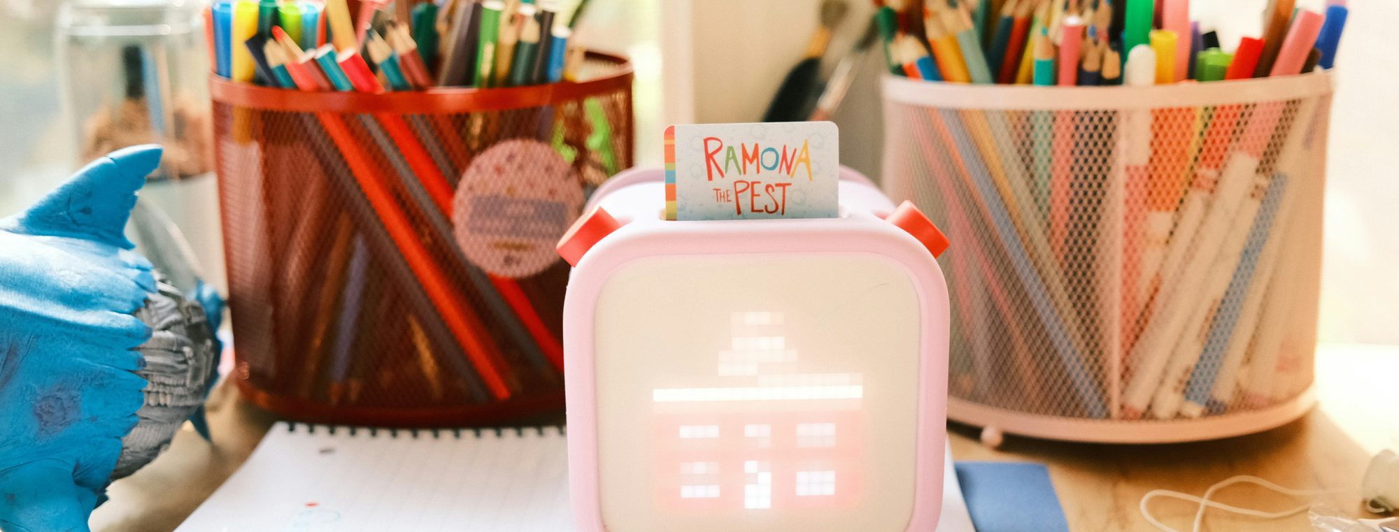 A homeschool table: pencil pots, paper and a morning's work